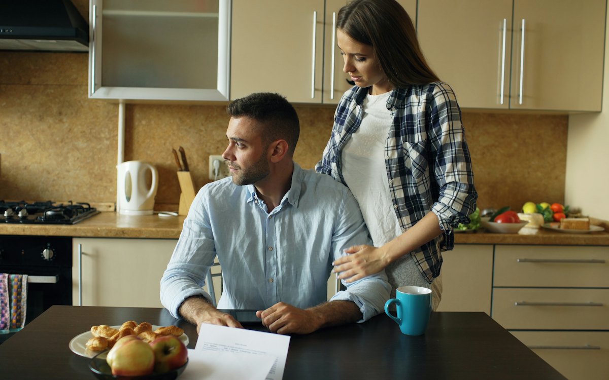 A couple going over paperwork together in their kitchen