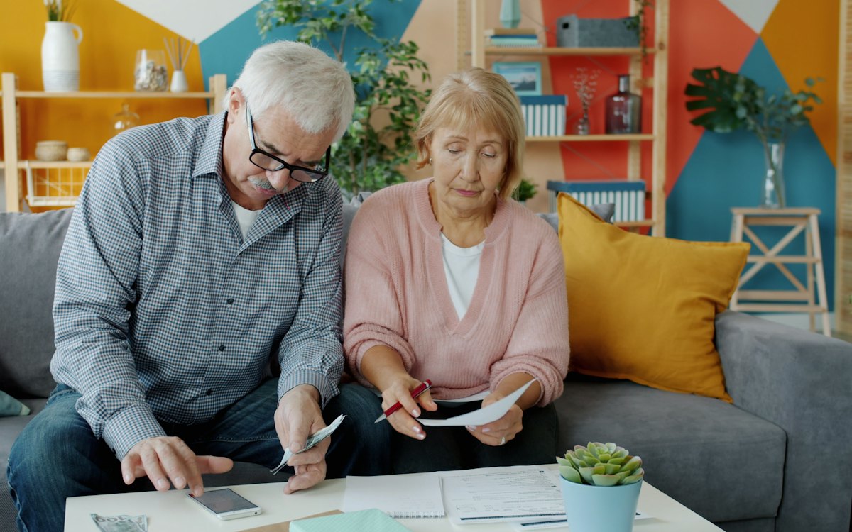 An older couple reviewing documents on their couch