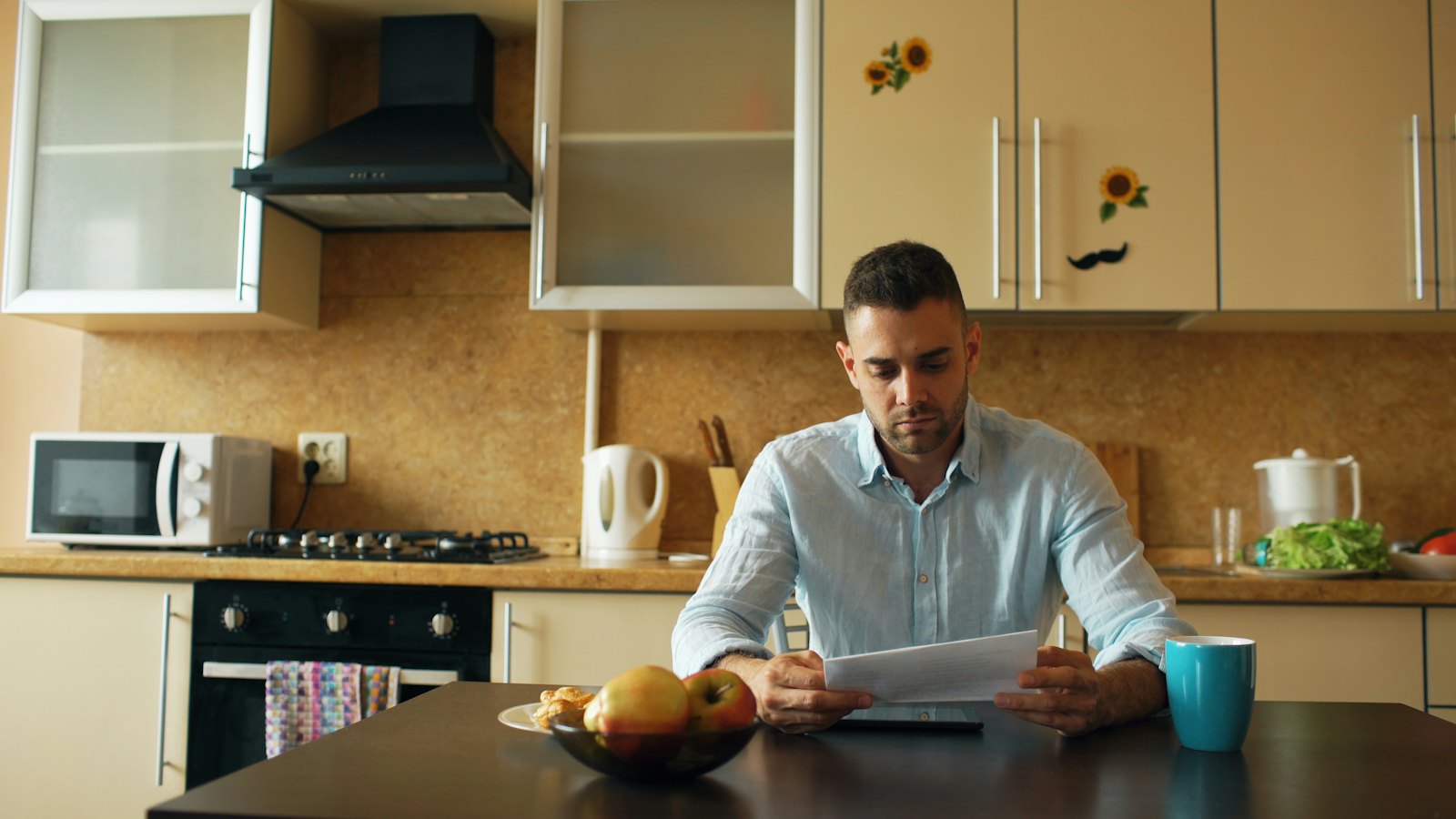 A man reading a document at his kitchen table