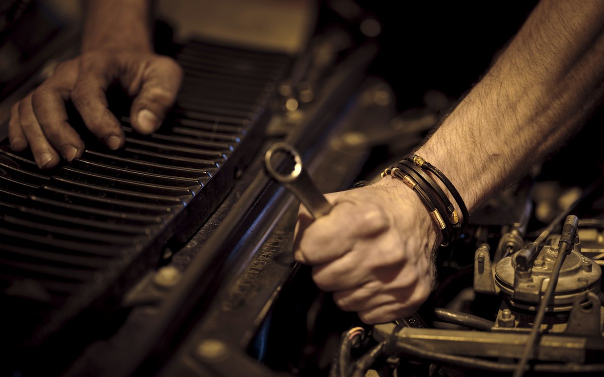 A mechanic working on a car engine with a wrench